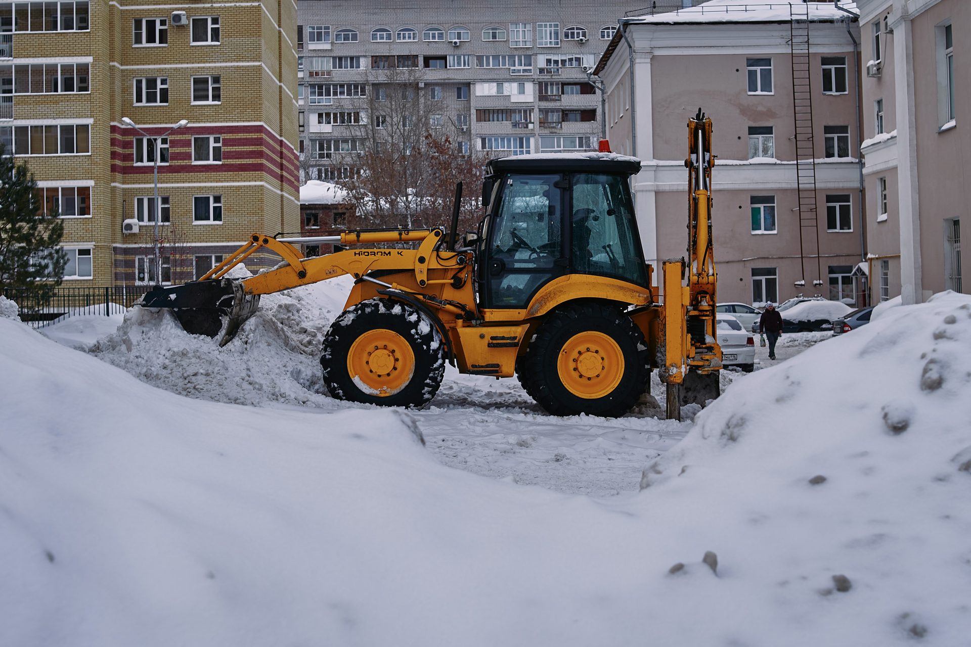 ein Bulldozer gräbt sich durch den Schnee in einer Stadt